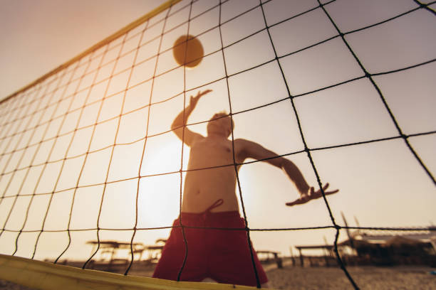 istock Beach volleyball player in action on the sand beach in sunset. 1327410378