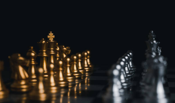 istock Gold and Silver king winner surrounded with silver chess pieces on chess board game competition.concept strategy, leadership and success business. 1327411410