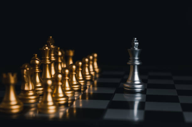 istock Silver king winner surrounded with silver chess pieces on chess board game competition.concept strategy, leadership and success business. 1327411446