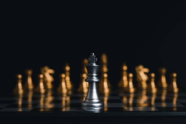 istock Silver king winner surrounded with silver chess pieces on chess board game competition.concept strategy, leadership and success business. 1327411456