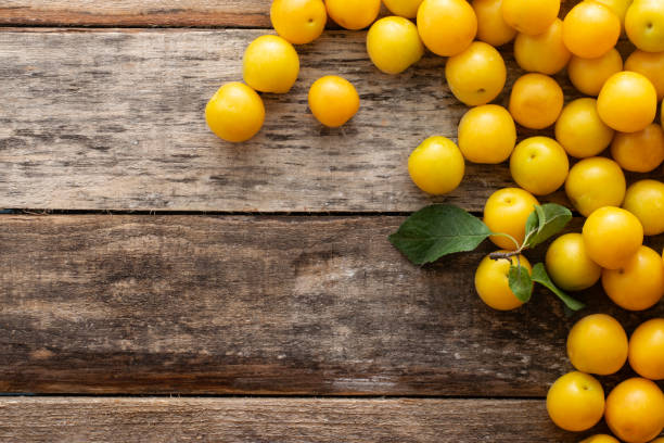 istock Yellow plum on a wooden rustic background with copy space. 1327416350