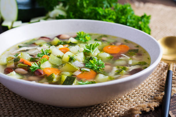 Chicken fillet vegetable soup in  bowl on wooden rustic table.