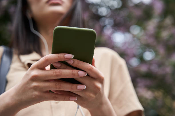 istock Female hearing songs while holding her smartphone and looking at mobile screen 1327424162