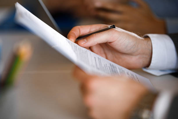 Close up of unrecognizable businessman going through paperwork on a meeting in the office.