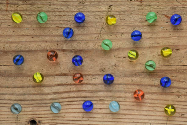 istock Colorful glass marbles on wooden background. 1327425721