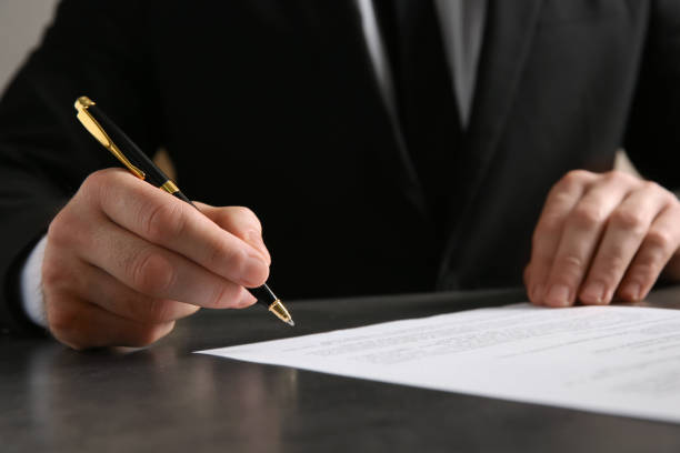 istock Male notary signing document at table, closeup 1327425792