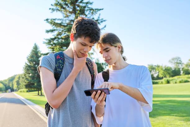 istock Teenagers friends talking looking at smartphone screen 1327425926