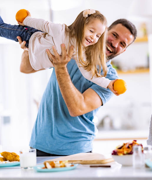 istock Cheerful single father having fun with his daughter in dining room. 1327426672
