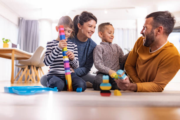istock Happy family talking while playing with toy blocks at home. 1327426799