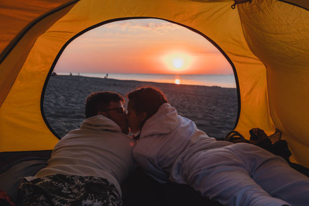 istock couple sleeping in camping tent looking at sunrise 1327427082
