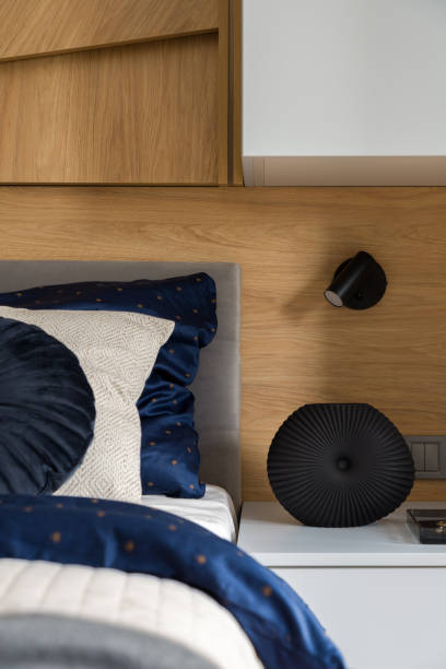 istock Nice vase on bedside table next to cozy bed 1327428188