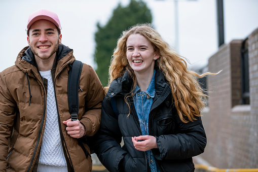 A close-up front-view shot of teenage friends walking up a concrete ramp in Wallsend, North East England. They are trying to catch the next train on the Subway.