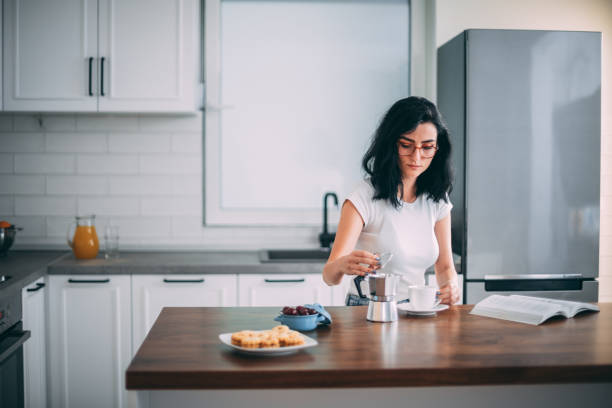 istock Beautiful young woman in kitchen 1327429701