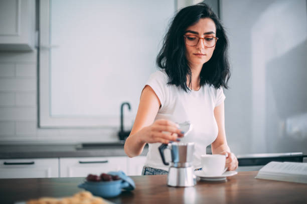 istock Beautiful young woman in kitchen 1327429722