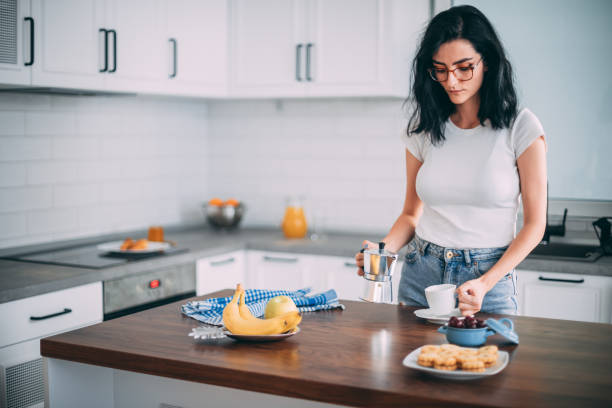 istock Beautiful young woman in kitchen 1327429735