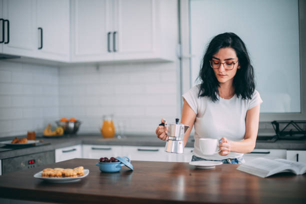 istock Beautiful young woman in kitchen 1327429737