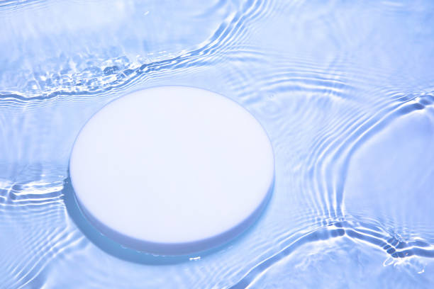 istock Empty white circle podium on transparent blue water background with copy space 1327433539