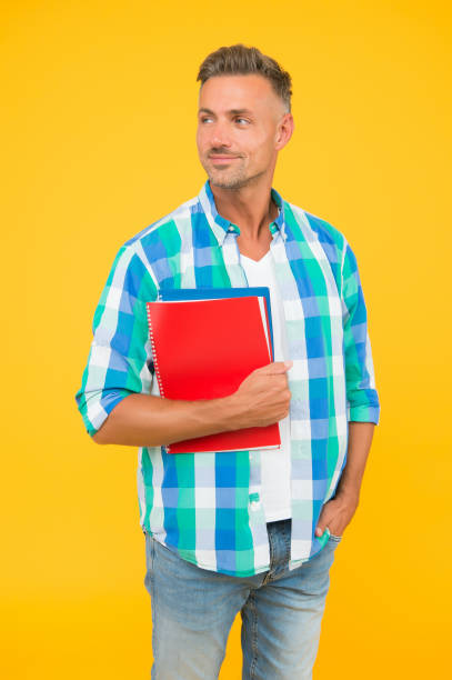 istock Free courses. Regular student carry workbooks. Student life. Dedicated to studying. Student with textbooks. Keep learning. College university education. Man adult student. Graduation concept 1327433629