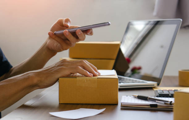istock Online seller holding phone mock up screen ad scan retail package parcel bar code on commercial shipping box delivery order on smartphone using mobile app. 1327434172