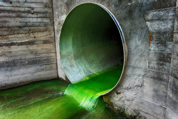 istock Bright green polluted effluent flowing through a drainage pipe 1327435292