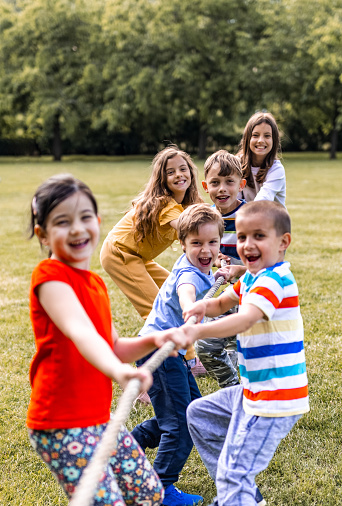 Group of children pulling a rope in public park
