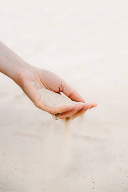 istock White sand pours through the fingers. 1327437094
