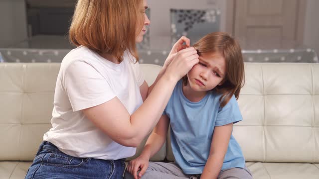 a girl complains of pain in ear and her mother examines it. children's diseases.