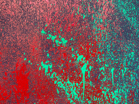Close up view of wall with splashed of red and green paint