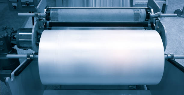 istock The operation of automatic plastic bag production machine with lighting effect. Close-up of the roller of the plastic bag production machine in the light blue scene. product packaging concept 1327440796