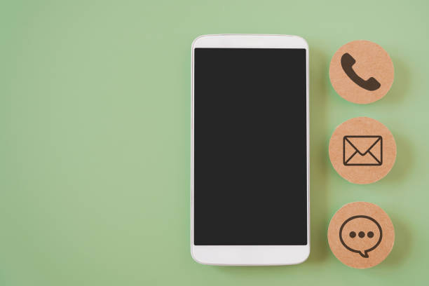 istock white mobile phone with clipping path on touchscreen and blurred brown contact method paper, contact us, call, mail or chat, question and answer ,new normal lifestyle , social distancing 1327440985