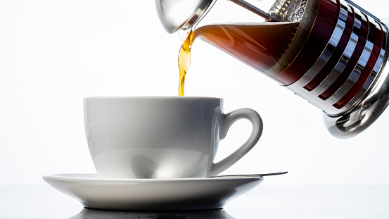 Coffee press in front of a white studio background.