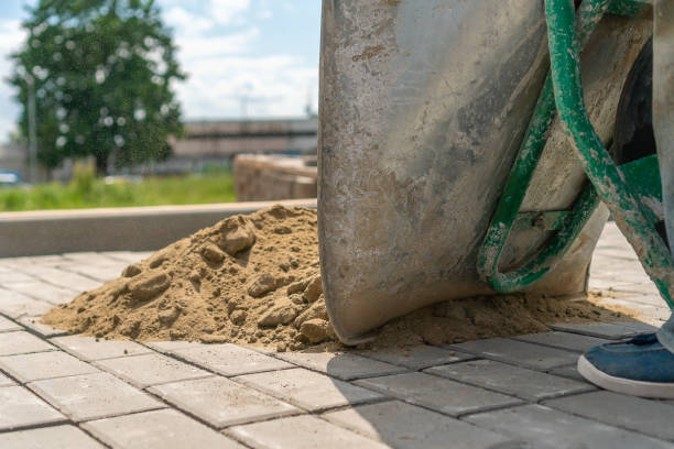 Close-up of a man from a construction wheelbarrow pouring sand on a new sidewalk to seal the cracks Close-up of a man from a construction wheelbarrow pouring sand on a new sidewalk to seal the cracks crevice photos stock pictures, royalty-free photos & images