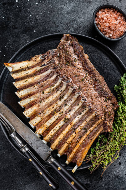 BBQ Grilled rack of Lamb mutton Ribs Chops on plate with thyme. Black background. Top view BBQ Grilled rack of Lamb mutton Ribs Chops on plate with thyme. Black background. Top view. rack of lamb stock pictures, royalty-free photos & images