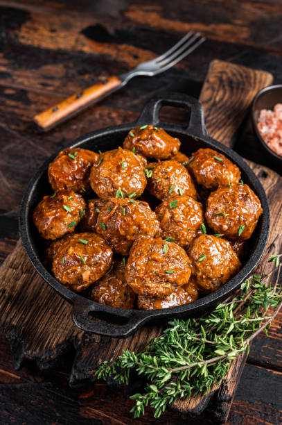 istock Meatballs in tomato sauce from beef and pork meat with thyme in rustic pan. Dark background. Top view 1327443744
