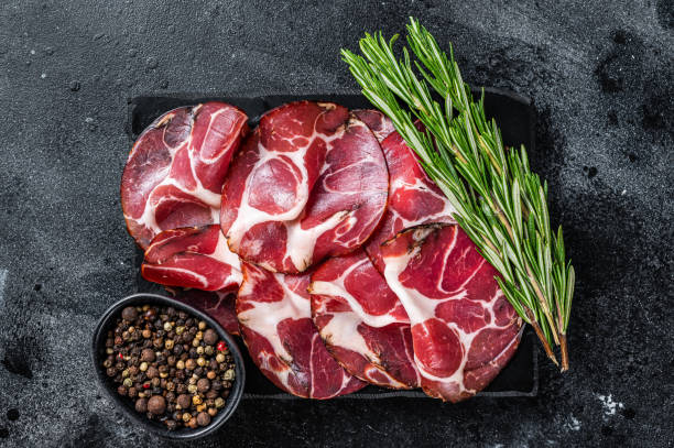 istock Coppa, Capocollo, Capicollo Cured ham on marble board. Black background. Top view 1327444699