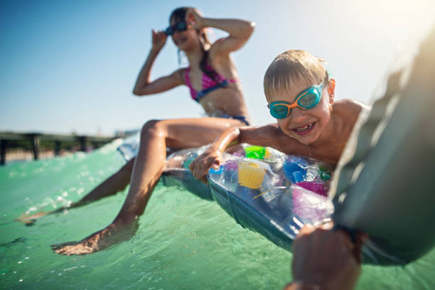 istock Funny kids floating in an inflatable boat 1327445929
