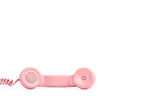 A vintage pink telephone on a white background with copy space