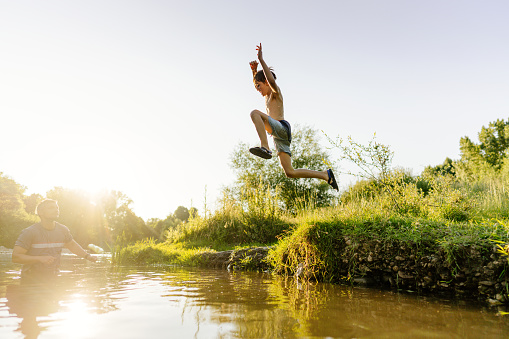 Photo of a boy jumping into the river