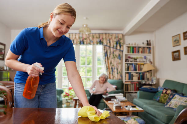 la casa femminile aiuta a pulire la casa e a parlare con la donna anziana - assistente domiciliare foto e immagini stock