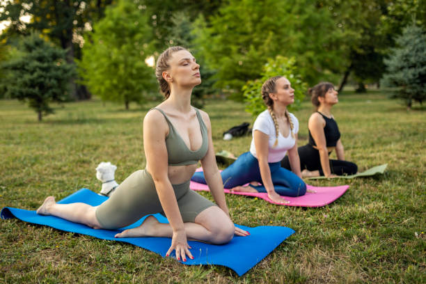 istock Young women on yoga class at public park 1327451050
