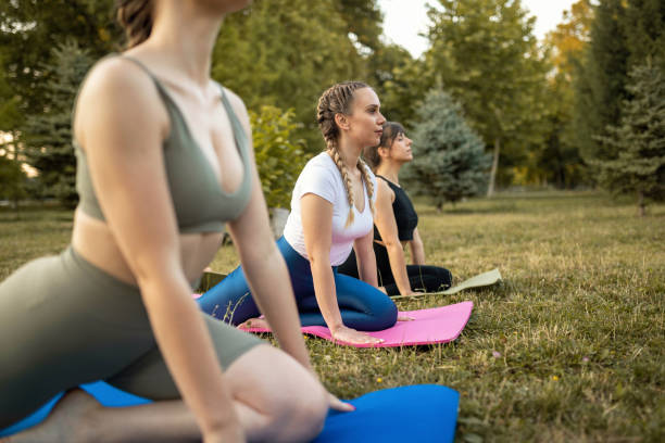 istock Young women on yoga class at public park 1327451212