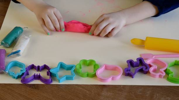 istock Toddler hands playing colorful play dough with plastic molds and rolling pin 1327451753