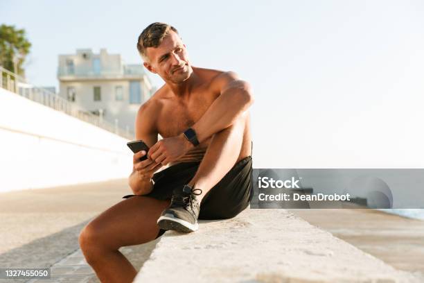Mature Sportsman Chatting By Mobile Phone Stock Photo - Download Image Now - Muscular Build, Men, Exercising