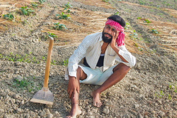 istock Young farmer sitting On His Field looking in the sky waiting for rain 1327455182