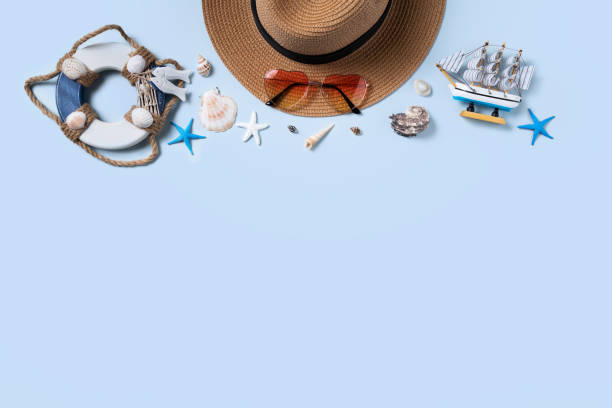 istock Summer beach background design concept with shells, hat, sunglasses on blue background. 1327455217