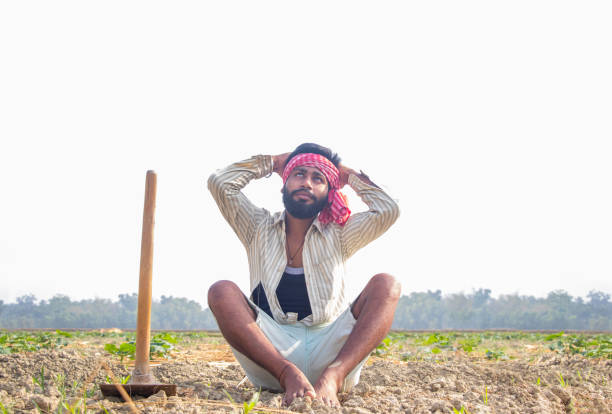 istock Young farmer sitting On His Field looking in the sky waiting for rain 1327455232