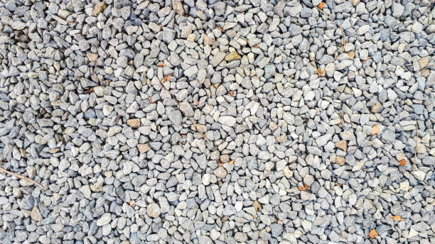istock Gravel texture. Pebble stone background. Light grey closeup small rocks. Top 1327455561