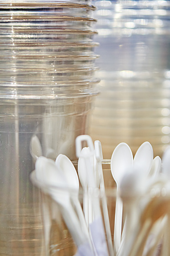 Plastic cups and spoons as background