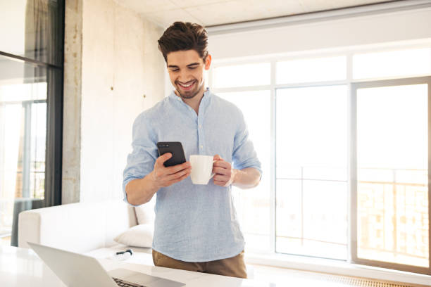 istock Portrait of a smiling young man using mobile phone 1327456750
