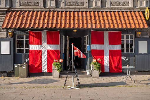 Façade of a bar with Danish flags in Nakskov which is the main city on the Danish island Lolland. The picture is taken during the European Soccer Championship